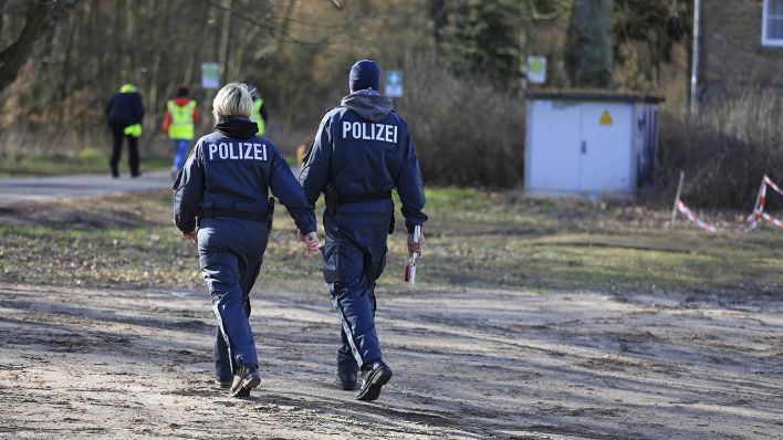 Zwei Beamte der Brandenburger Polizei bei einem Einsatz in einem Waldgebiet (Quelle: imago/Simone Kuhlmey)