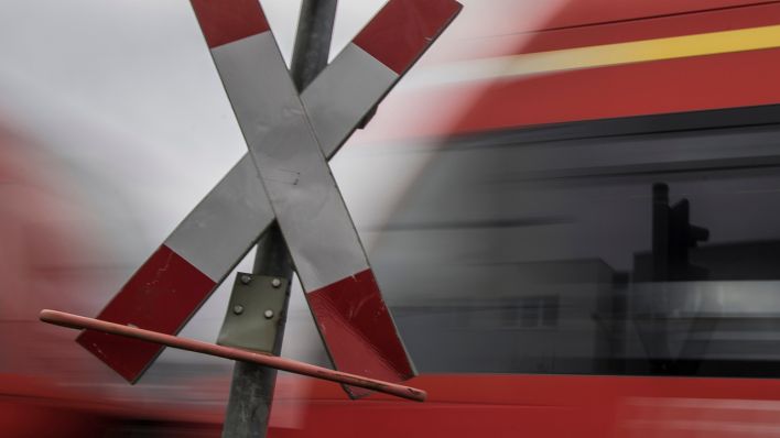 Ein Regionalzug der Deutschen Bahn quert einen unbeschrankten Bahnübergang (Symbol)