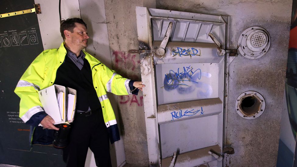 Jörg Diester entriegelt die Stahltür eines Bunkers in Gosen bei Berlin. (Quelle: dpa/Wolfgang Kumm)