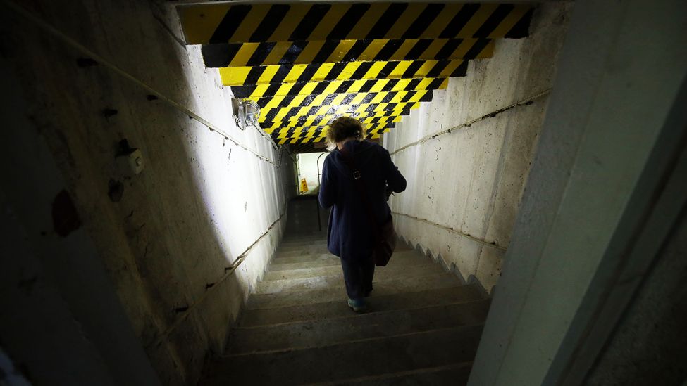 Eine Frau geht die Stufen eines Bunkers hinab. (Quelle: dpa/Wolfgang Kumm)