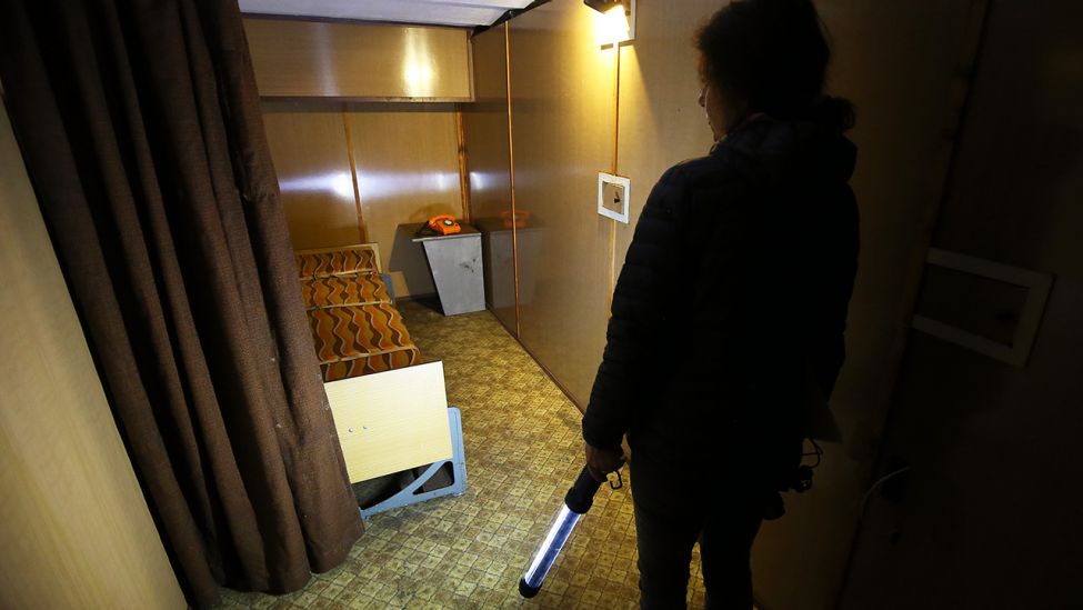 Eine Frau betrachtet in einem Bunker vom Typn V2C, im Zimmer von Spionagechef Markus Wolf den Schlafbereich. (Quelle: dpa/Wolfgang Kumm)