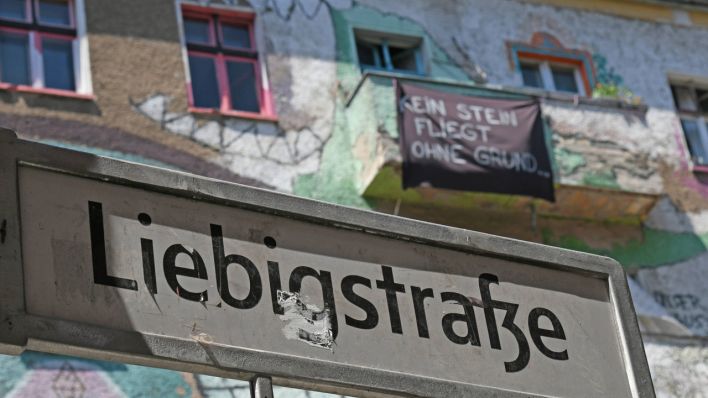 Besetztes Haus mit Graffitis in der Liebigstrasse in Berlin- Friedrichshain. Auf dem Transparent steht: Kein Stein fliegt ohne Grund.