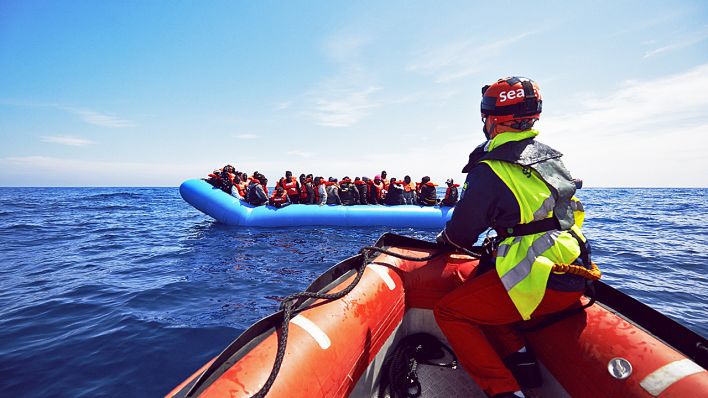 Ein Rettungsboot der NGO Sea-Watch nähert sich einer Gruppe Flüchtlinge vor der libyschen Küste, April 2019 (Quelle: dpa/Heinz)