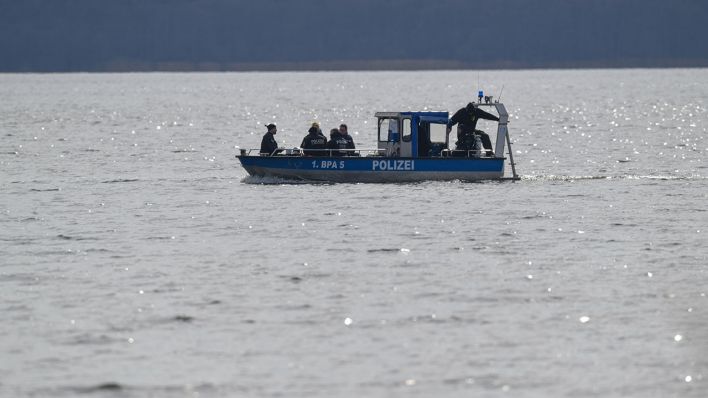 Polizeitaucher auf einem Boot in einem See (Symbolbild: dpa/Patrick Pleul)