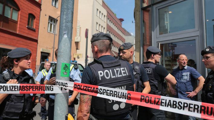 Köln: Polizisten stehen vor einem Wohngebäude in der Innenstadt hinter einem Absperrband.