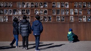 Bernauer Strasse, Berlin, Touristen und Kinder vor der Bilderwand mit Fotos von Maueropfern (Quelle: Imago images)