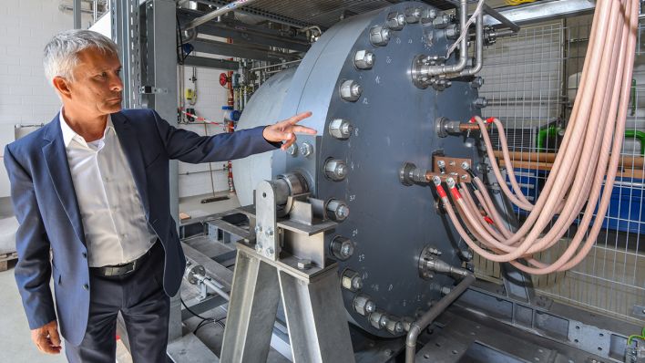 Ulrich Fischer, Leiter des Wasserstoff-Forschungszentrums an der BTU - Brandenburgische Technische Universität, steht am 16.08.2019 an einem alkalischen Druckelektrolyseur, der zur Erzeugung von Wasserstoff benötigt wird. (Quelle: dpa/Patrick Pleul)