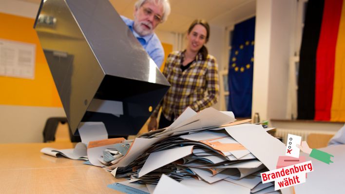 Wahlhelfer leeren eine Wahlurne mit Stimmzetteln (Quelle: dpa/Monika Skolimowska)