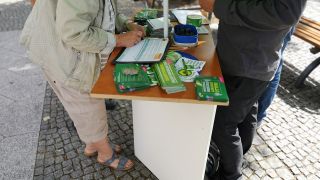 Eine Bürgerin unterschreibt in einer Unterschriftensammlung für ein Volksbegehren zum Insektenschutz an einem Wahlkampfstand der Grünen am 16.08.19 in der Bahnhofstraße in Königs Wusterhausen (Quelle: rbb|24 / Schneider).