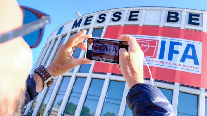 Ein Besucher der Elektronikmesse IFA fotografiert ein Banner am Eingang (Quelle: Messe Berlin)