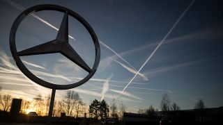 Die Sonne geht hinter einem Mercedes-Stern auf (Bild: dpa/Sebastian Gollnow)