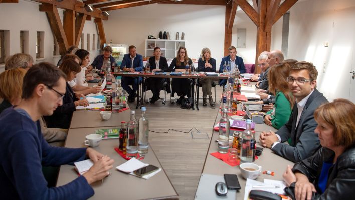 Vertreter der Parteien Grüne (links), Linke (hinten) und SPD (rechts) sitzen vor Beginn der Sondierungsgespräche über eine mögliche Koalition im Sitzungsraum. (Quelle: dpa/Monika Skolimowska)