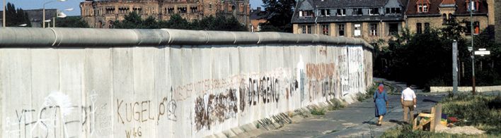 Ein Paar spaziert an der Berliner Mauer in Kreuzberg entlang (Quelle: imago images/Günter Schneider)