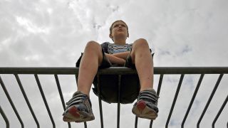 Junge sitzt auf einem Tor (Quelle: imago images/JOKER/WalterxG.)