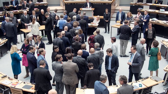 Während einer Abstimmung über eine Diätenerhöhung steht eine Gruppe an Politikern und Politikerinnen im Berliner Abgeordnetenhaus (Bild: imago images/Olaf Wagner)