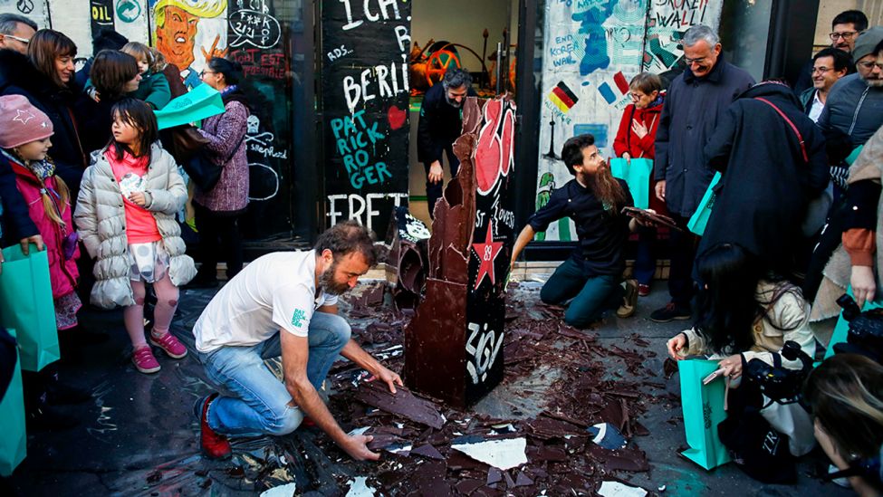 Der französische Schokoladenhersteller Patrick Roger, Mitte, zerstört eine Reproduktion der Berliner Mauer in Schokolade anlässlich des 30. Jahrestages des Mauerfalls in Paris, Samstag, 9. November 2019. (Quelle: dpa/Camus)