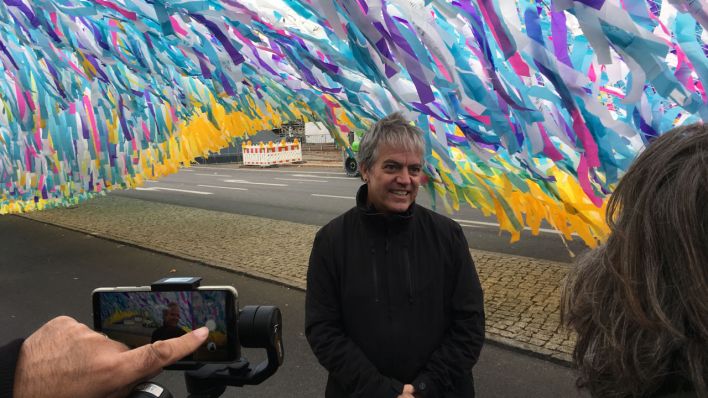 Patrick Shearn unter seiner Installation am Brandenburger Tor (Bild: rbb/David Donschen)