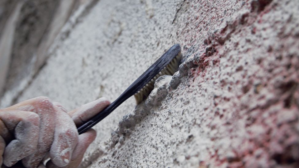 Eine Person schrubt eine Wand mit einer Kletterbürste (Bild: rbb/Bettina Rehmann)