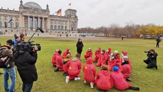 Mitglieder von <<Ende Gelände>> werden von Kamerateams vor dem Reichstag in Berlin gefilmt. (Quelle: rbb/P. Manske)