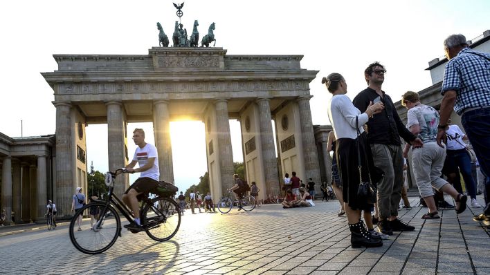 Fußgänger und Radfahrer auf dem Pariser Platz am Brandenburger Tor in Berlin. (Quelle: imago-images/Michael Kneffel)