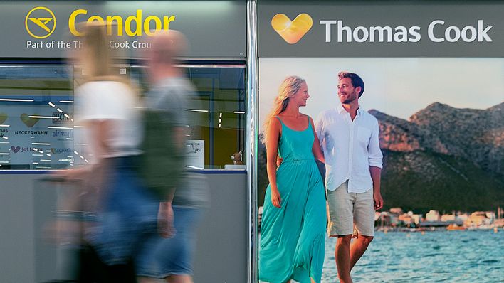 12.10.2019, Spanien, Palma: Ein Mann und eine Frau laufen auf dem Flughafen Palma de Mallorca an einem geschlossenen Büro von Condor und Thomas Cook vorbei. (Quelle: dpa/Schulz)
