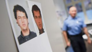 Symbolbild: Fahndungsfotos des im Zusammenhang mit dem Terroranschlag von Berlin gesuchten Tunesiers Anis Amri hängen in einer Polizeiwache. (Quelle: dpa/A. Dedert)
