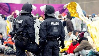 Zwei Polizisten der Bundespolizei stehen vor Teilnehmern des Antikohlebuendnisses "Ende Gelände" in der Lausitz (Bild: dpa/Andreas Franke)