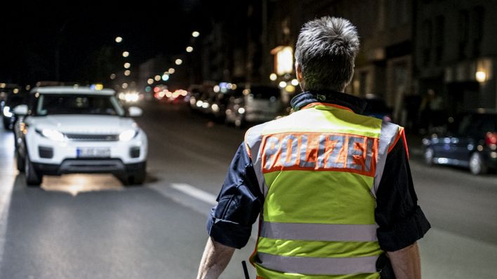 Symbolbild: Berlin: Ein Polizeibeamter winkt bei einer Verkehrskontrolle Fahrzeuge aus dem Verkehr. (Quelle: dpa/Paul Zinken)