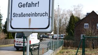 Ein Hinweisschild in der Wilhelm-Külz-Straße weist auf Gefahren auf Grund von Altbergbaufolgen hin. (Quelle: dpa/Steffen Rasche)