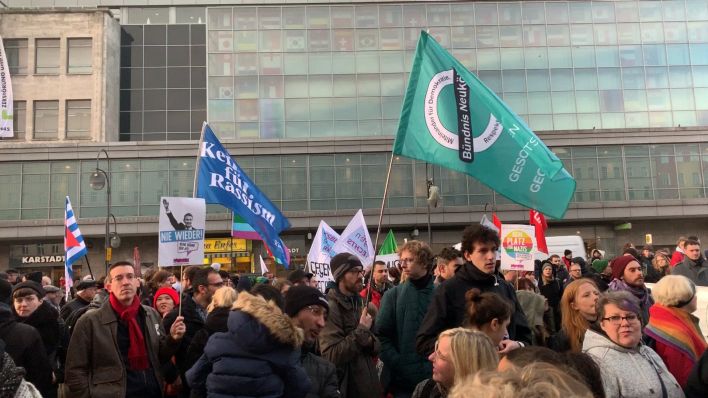 Demonstranten am Hermannplatz halten Plakate hoch und schwenken Fahnen (Quelle: rbb/Grit Lieder)