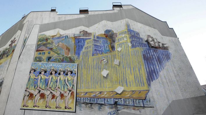 Auf einer Brandschutzwand an einem Haus in der Neukölln Donaustraße ist ein gemaltes Bild mit dem alten Karstadt-Gebäude am Hermannplatz zu sehen.