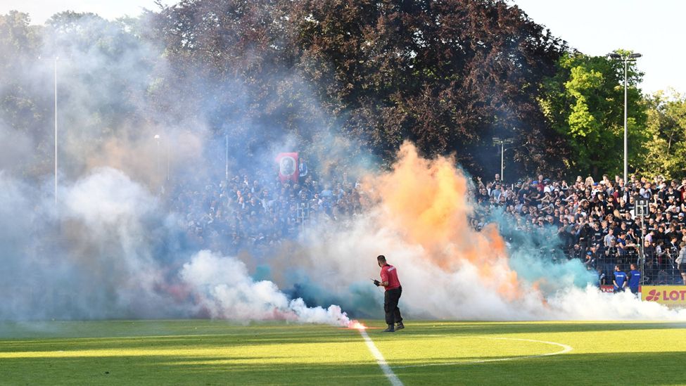 Pyrotechnik, geworfen von Babelsberger Fans, verhindert die Siegerehrung. Quelle: imago images/Matthias Koch