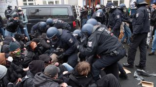 Polizisten lösen am 22.11.2020 eine Sitzblockade von Demonstranten auf, die gegen den als «Schweigemarsch» bezeichneten Protestzug gegen die Corona-Politik protestieren, der auf der Bornholmer Straße entlangzieht. (Quelle: dpa/Paul Zinken)