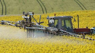 Pflanzenschutzmittel wird mit einem Traktor auf einem Feld versprüht (Quelle: blickwinkel/W. Pattyn)