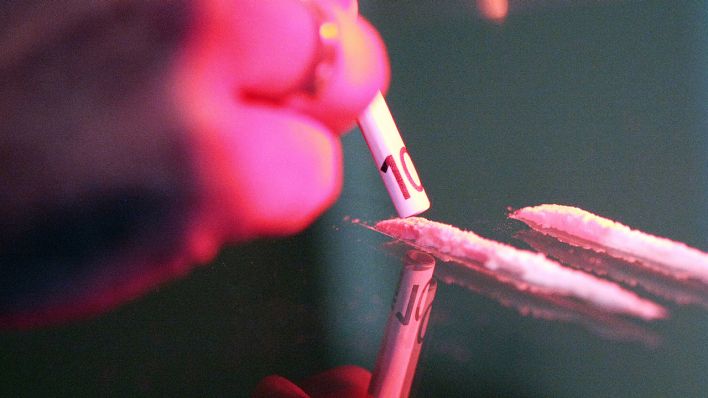Symbolbild: Hand eines Drogenkonsumenten, der auf dem Tisch zwei Kokain-Linien vorbereitet hat, um sie durch einen aufgerollten 10-Euro-Schein zu schnupfen. (Quelle: dpa/M. Begsteiger)