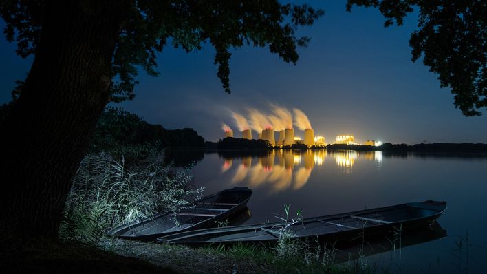 Hinter einem Karpfenteich steigt am späten Abend Wasserdampf aus den Kühltürmen des Braunkohlekraftwerks Jänschwalde der Lausitz Energie Bergbau AG (LEAG). Quelle: dpa/Patrick Pleul