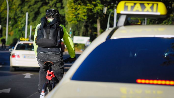 Symbolbild: Ein Radfahrer fährt neben einem Taxi (Quelle: imago images/Jürgen Ritter)