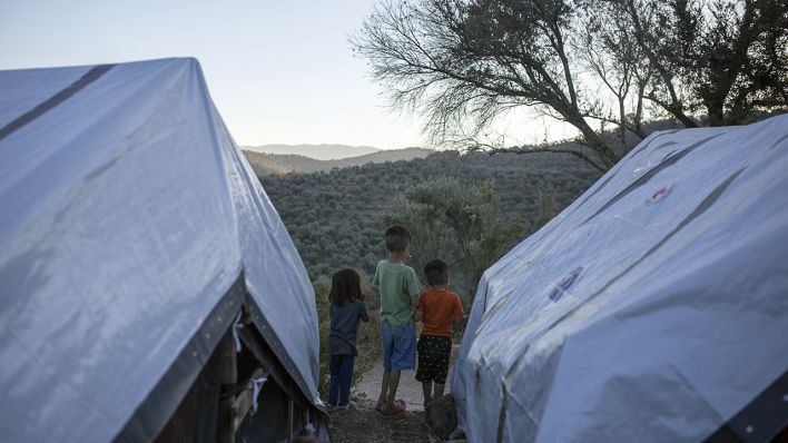 Drei Kinder stehen zwischen Zelten in einem provisorischen Lager neben dem Flüchtlingslager von Moria. (Quelle: dpa/Socrates Baltagiannis)