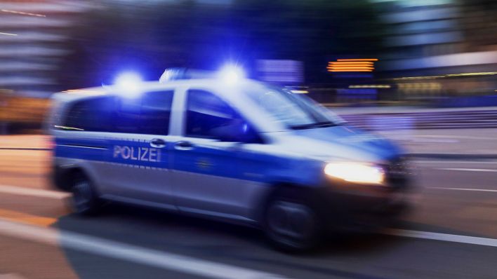 Symbolbild: Ein Polizeifahrzeug fährt mit Blaulicht durch die nächtliche Innenstadt. (Quelle: dpa/J. Woitas)