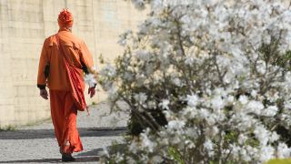 Symbolbild: Ein Sannyasin Sektenmitglied in orange farbener Kleidung geht in Berlin im Regierungsviertel spazieren. (Quelle: dpa/P. Zinken)