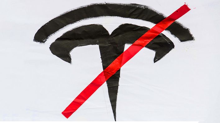 Tesla-Logo auf einem Protesttransparent (Quelle: imago-images/Ditsch)