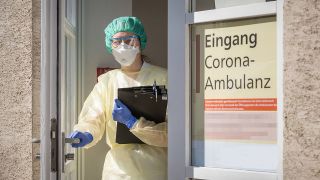 Symbolbild: Eine Infktiologin steht in der Tür einer Corona Ambulanz. (Quelle: imago imgages)