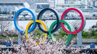 Die Olympischen Ringe in Tokio hinter einem blühenden Kirschbaum (Quelle: imago images/ZUMA Wire)