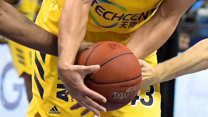 Alba-Spieler haben die Hand an einem Basketball (Quelle: imago images/Jan Huebner)
