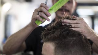 Friseur schneidet Mann die Haare (Bild: imago images/westend61)