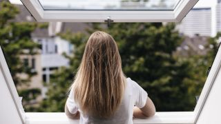 Frau schaut aus dem Fenster (Quelle: imago images/Gustafsson)