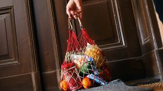 Einkaufsnetz mit Lebensmitteln hängt an der Tür einer isolierten Person (Quelle: imago images/Sabine Gudath)
