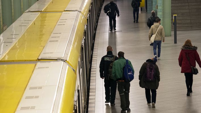 Menschen gehen am 23.03.2020 im U-Bahnhof Alexanderplatz an einer U-Bahn vorbei (Quelle: dpa/Paul Zinken)
