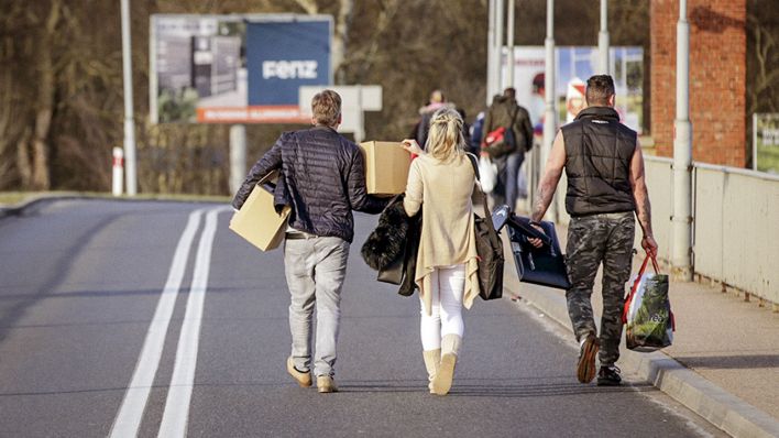 Passanten tragen Gegenstände über die Grenze von Küstrin nach Kostrzyn. Die Grenzen zwischen Polen und Deutschland sind wegen des Coronavirus geschlossen. (Quelle: dpa/Bungert)