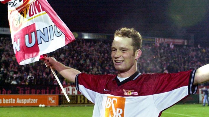 Union-Abwehrspieler Daniel Ernemann dreht mit der Vereinsfahne in der Hand jubelnd eine Ehrenrunde (Quelle: dpa/Bernd Settnik)
